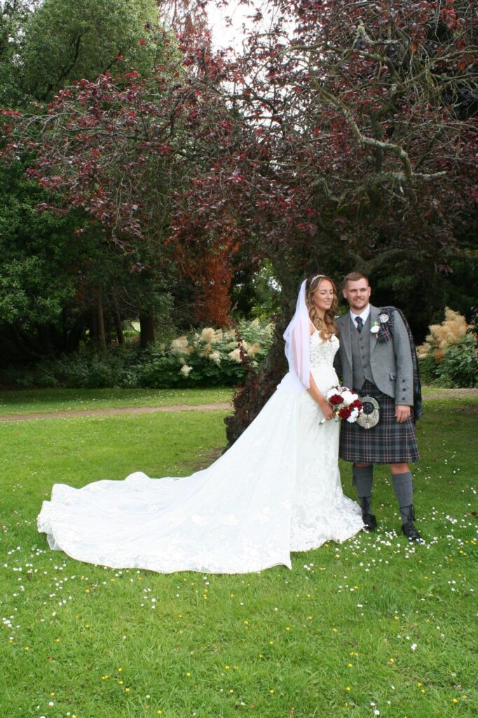 Bride Abbi and her groom in a kilt after professional wedding dress and formal wear alterations in Dunfermline.