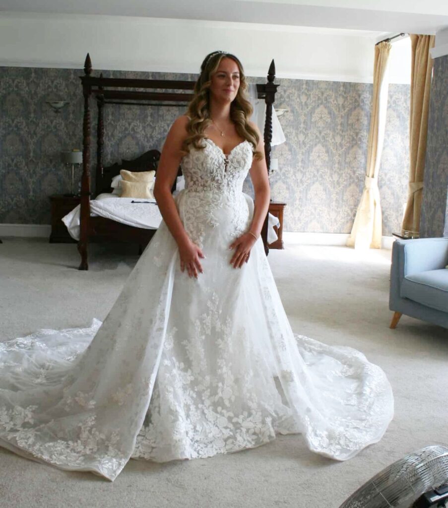 Real Bride Abbi wearing a custom-fitted lace wedding dress with tailored skirt enhancements.